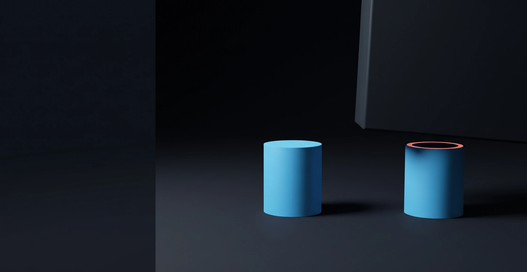 Two cylinders of exactly the same height side by side; above the left one only empty space, on the right one a coral ring resting on top